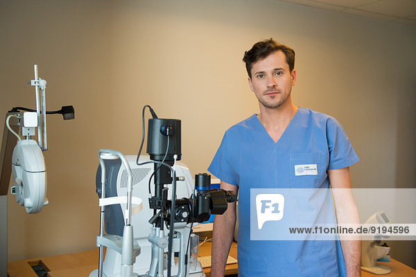 Male doctor with eye test equipment