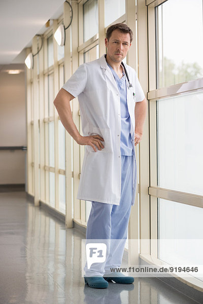 Male doctor standing near a window in a hospital