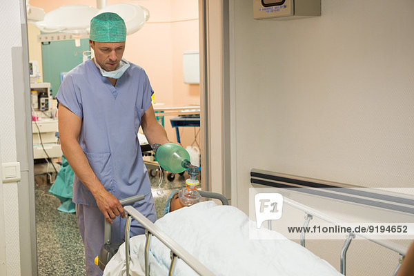Surgeon moving patient into operating room
