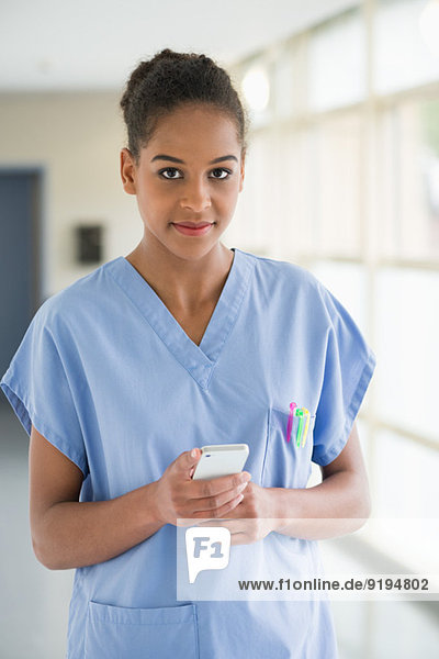 Portrait einer Krankenschwester Textnachricht mit einem Mobiltelefon