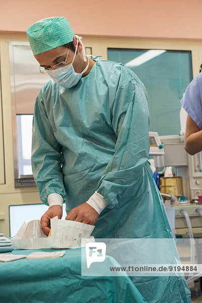 Male surgeon preparing for a operation in an operating room