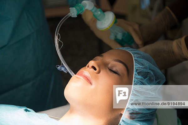 Patient with oxygen mask in an operating room