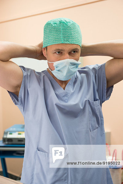 Male surgeon wearing surgical mask in an operating room