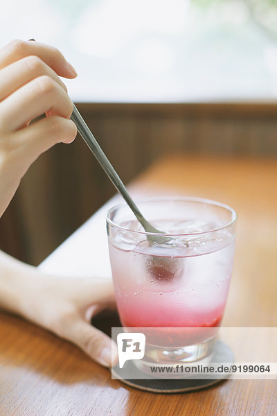 Young Japanese woman with raspberry soda in a cafe
