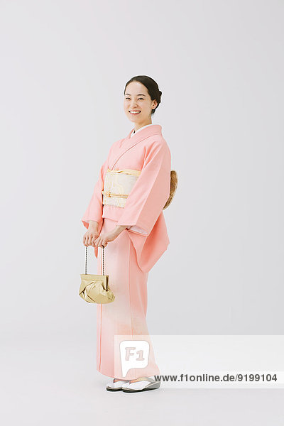 Young Japanese woman in a traditional kimono against white background