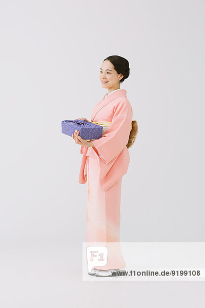 Young Japanese woman in a traditional kimono against white background
