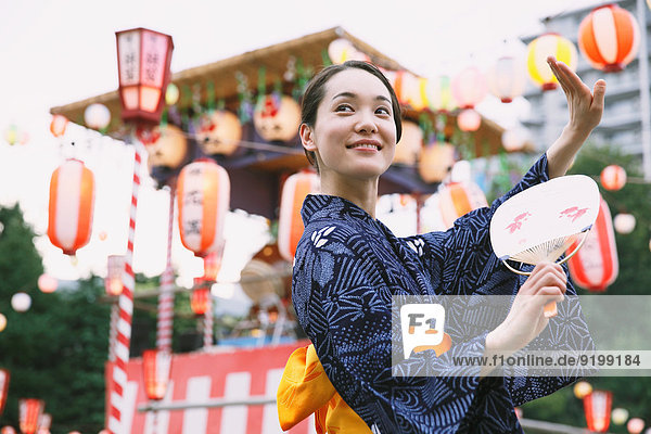 Young Japanese woman in a traditional kimono at a summer festival