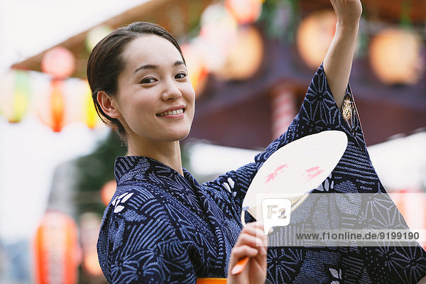Young Japanese woman in a traditional kimono at a summer festival