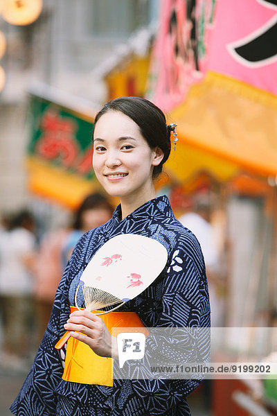 Young Japanese woman in a traditional kimono at a summer festival