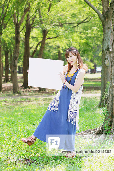 Japanese woman with white board in a park
