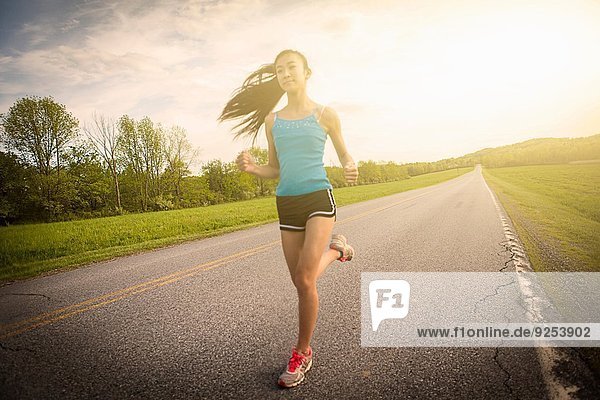Teenage girl running on road