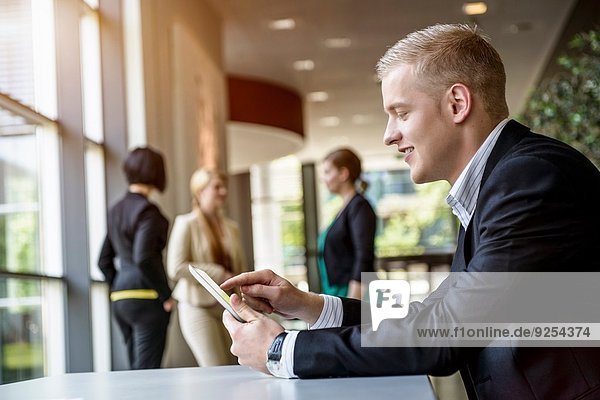 Young man using touchscreen on digital tablet in office