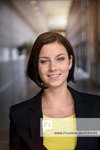 Portrait of young businesswoman in office corridor