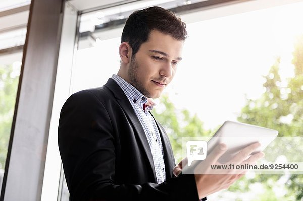 Young businessman in office using digital tablet