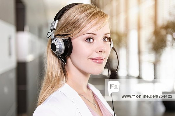 Portrait of young businesswoman using telephone headset