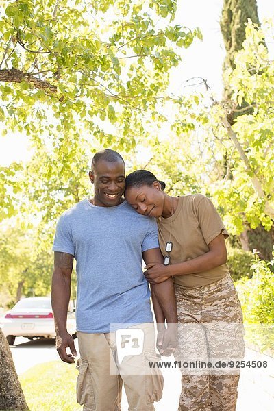 Soldatin ruht mit dem Kopf auf der Schulter des Ehemannes beim Bummeln auf der Heimkehr