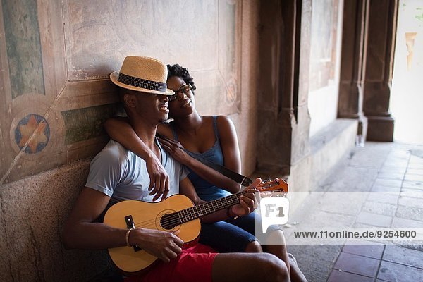 Young couple sitting with mandolin in Bethesda Terrace arcade  Central Park  New York City  USA
