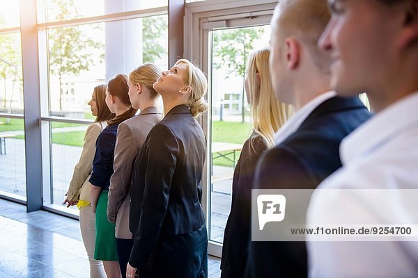 Businesswomen and men waiting in a row in office