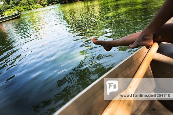Schnittbild der Beine einer jungen Frau im Ruderboot auf dem See im Central Park  New York City  USA
