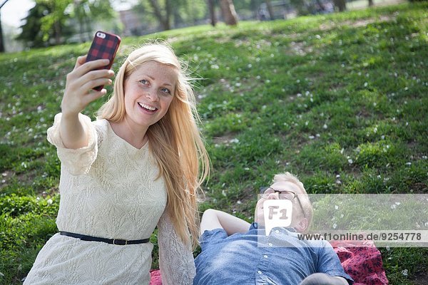 Junges Paar nimmt Selfie mit Smartphone im Park mit