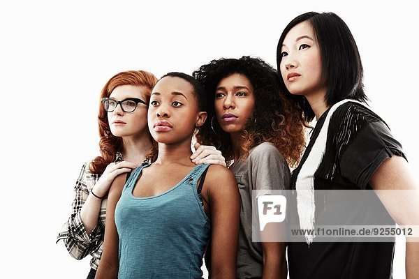 Studio-Porträt von vier seriösen jungen Frauen