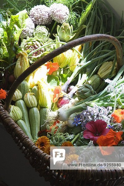 Korb mit frischem Biogemüse und Blumen