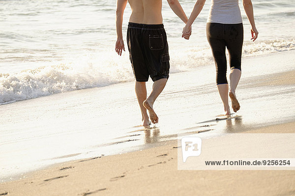 Couple walking on beach  low section