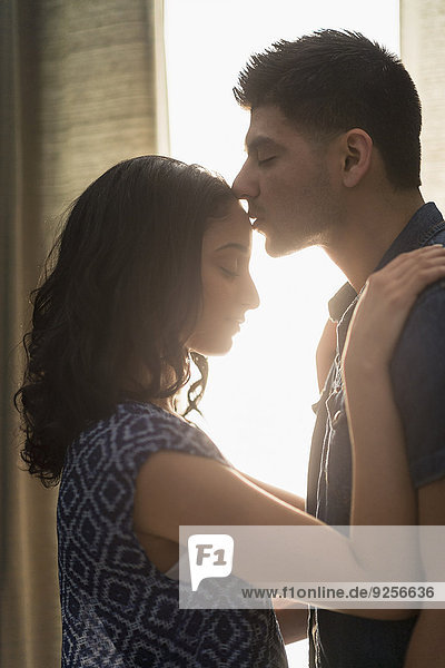 Young couple kissing in sunlight