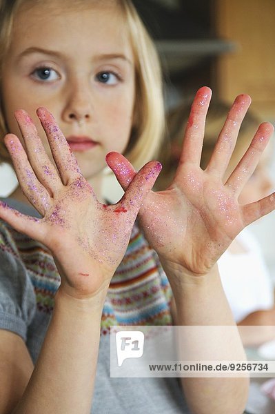 Mädchen zeigt seine verschmierten Hände