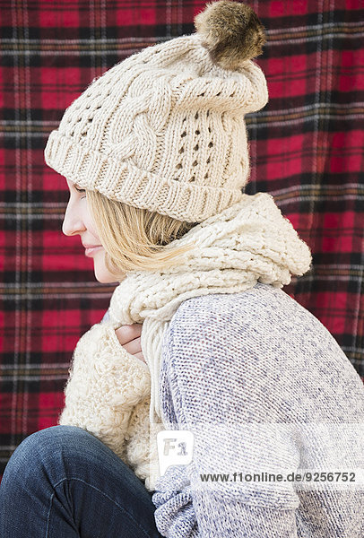 Profile of woman wearing knit hat and scarf