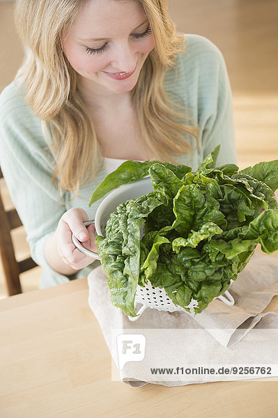 Woman holding colader full with kale