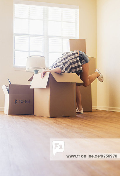 Young woman looking into box in her new house