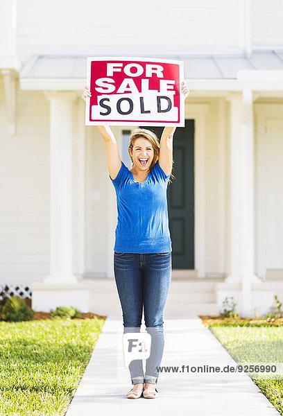 Woman holding for sale sign