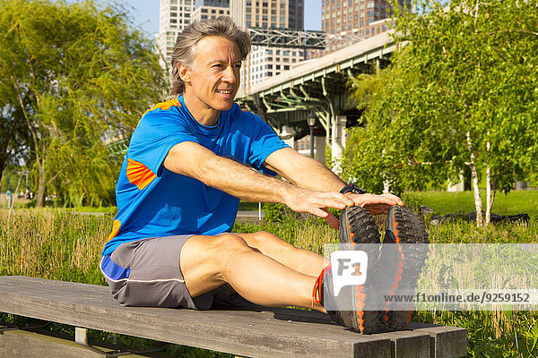 Caucasian man stretching in urban park