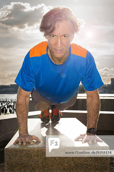 Caucasian man doing push ups in urban park
