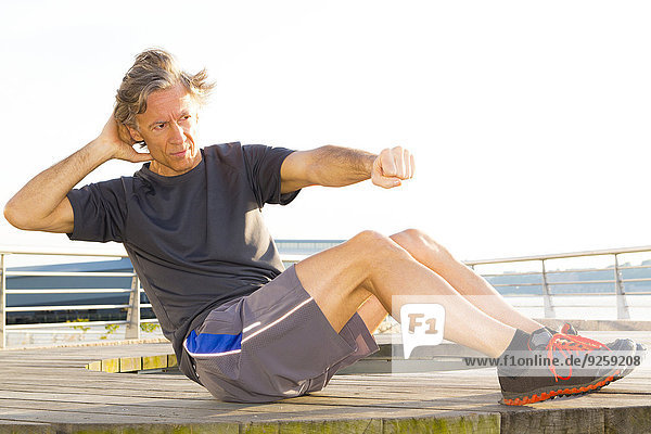 Caucasian man exercising in waterfront park