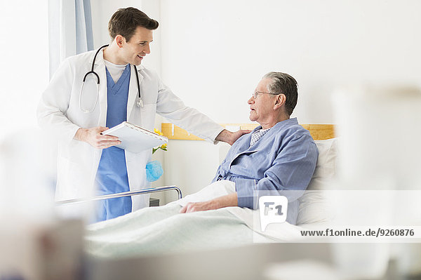 Caucasian doctor talking to Senior patient in hospital