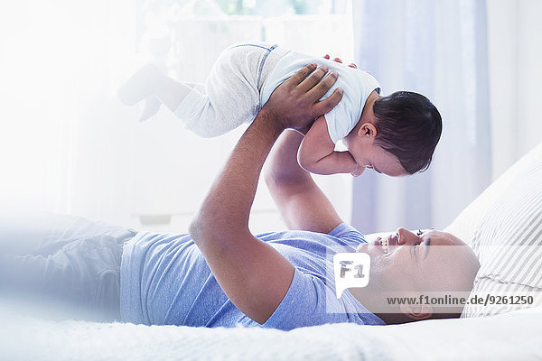 Menschlicher Vater Bett Baby spielen