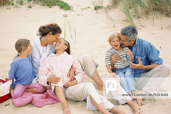 Caucasian family having picnic on beach
