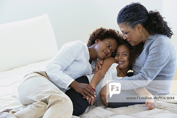 Three generations of women relaxing on bed