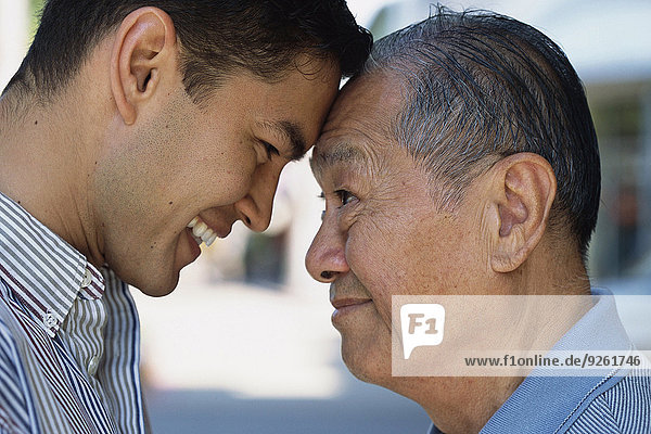 Senior man and son smiling outdoors