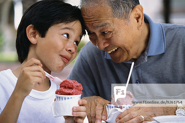 Außenaufnahme Senior Senioren Mann Eis Enkelsohn essen essend isst Sahne freie Natur