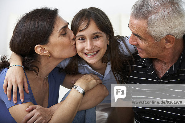 Hispanic family smiling together on sofa