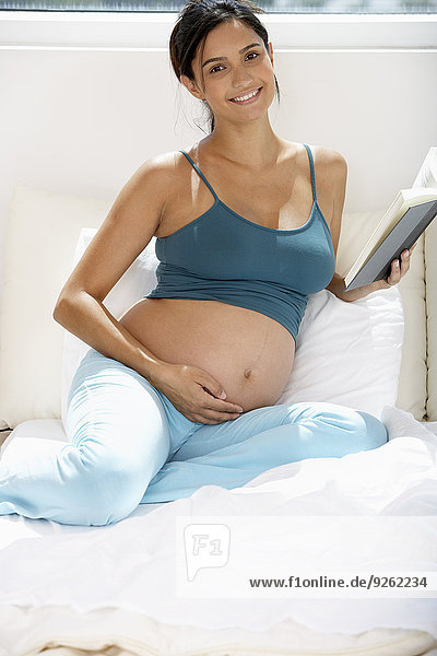 Frau Hispanier Bett Schwangerschaft vorlesen
