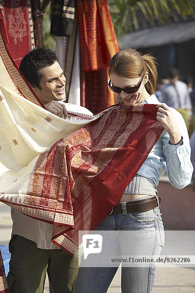 Couple admiring fabrics at outdoor market
