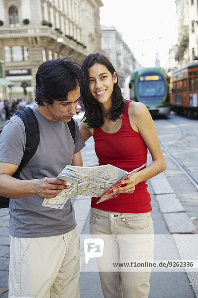 Couple reading map on city street