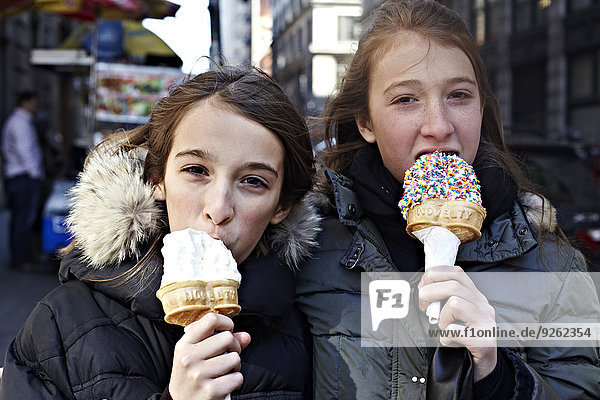 Girls eating ice cream on city street