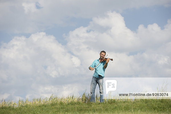 Germany  Bavaria  Starnberg Region  Man playing violin in nature