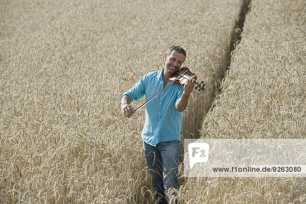 Germany  Bavaria  Starnberg Region  Man playing violin in field