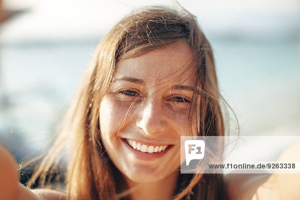 Indonesien  Gili Inseln  Portrait einer glücklichen Frau am Strand